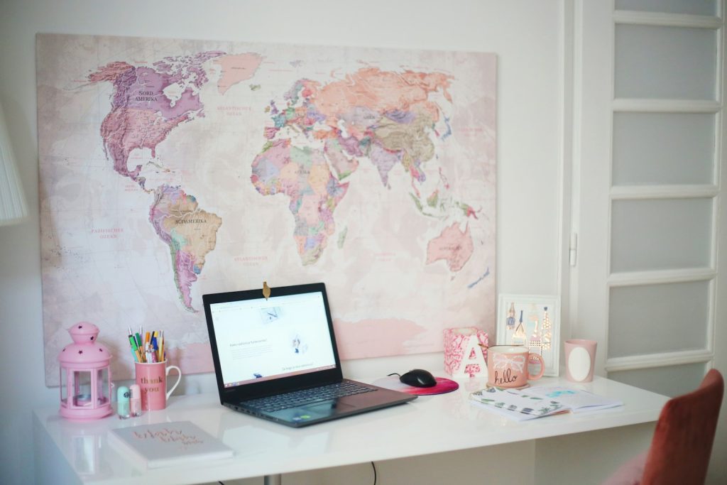 Laptop on a desk in front of a world map
