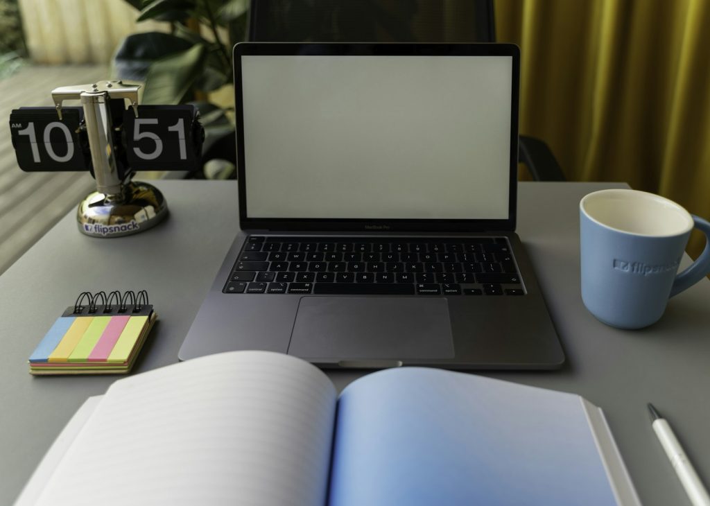 Laptop, notebook and mug on a desk for planning ideas