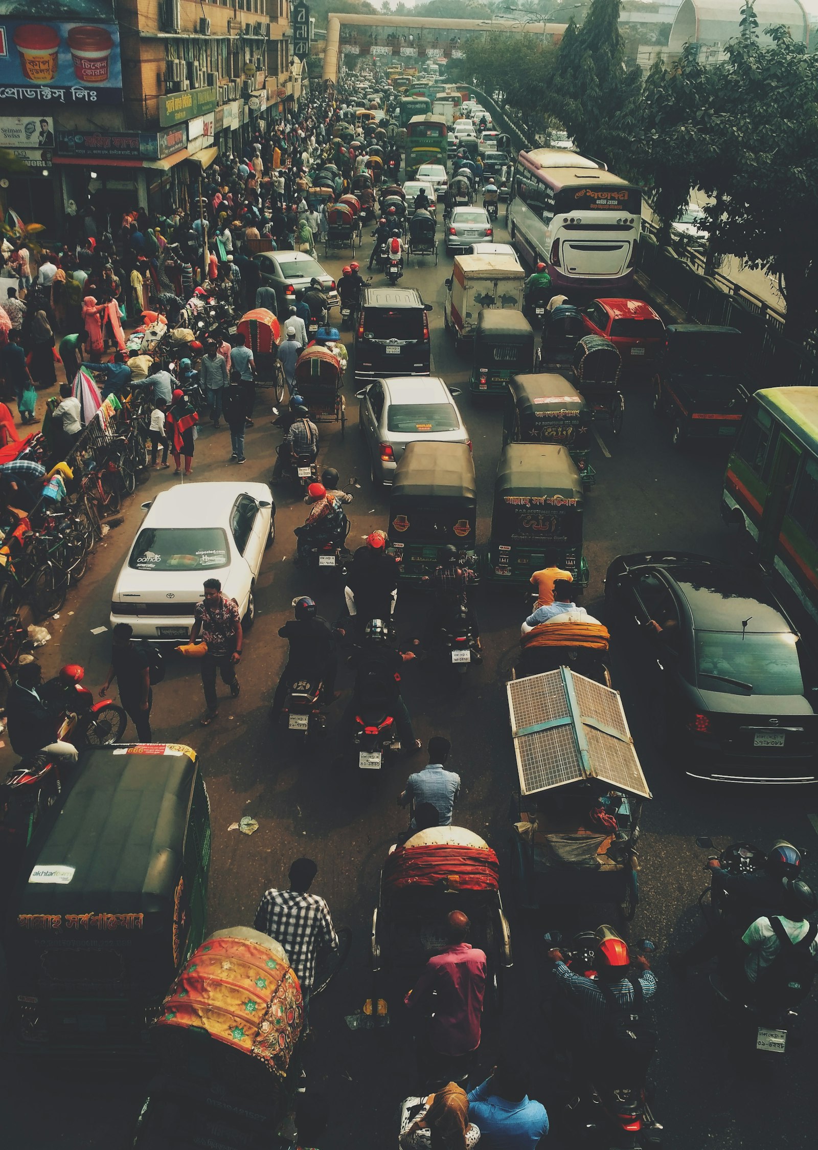 Rickshaws and traffic on a crowded Dhaka street