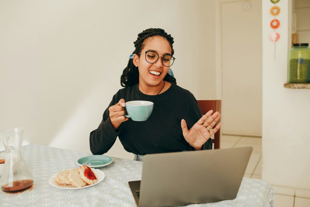 Woman on a video call at her laptop holding a coffee mug