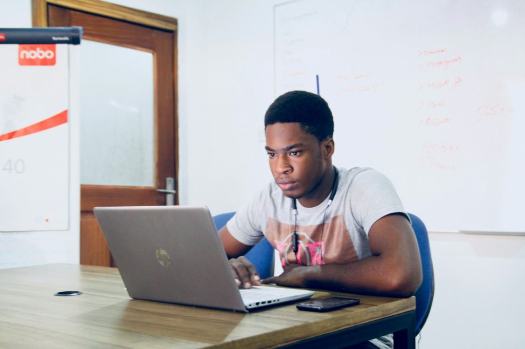 Young man studying online on a laptop at a desk