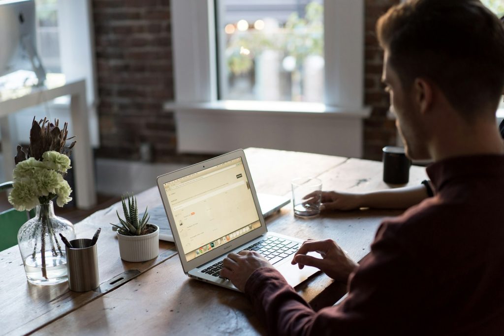 Blogger working on a laptop by a window