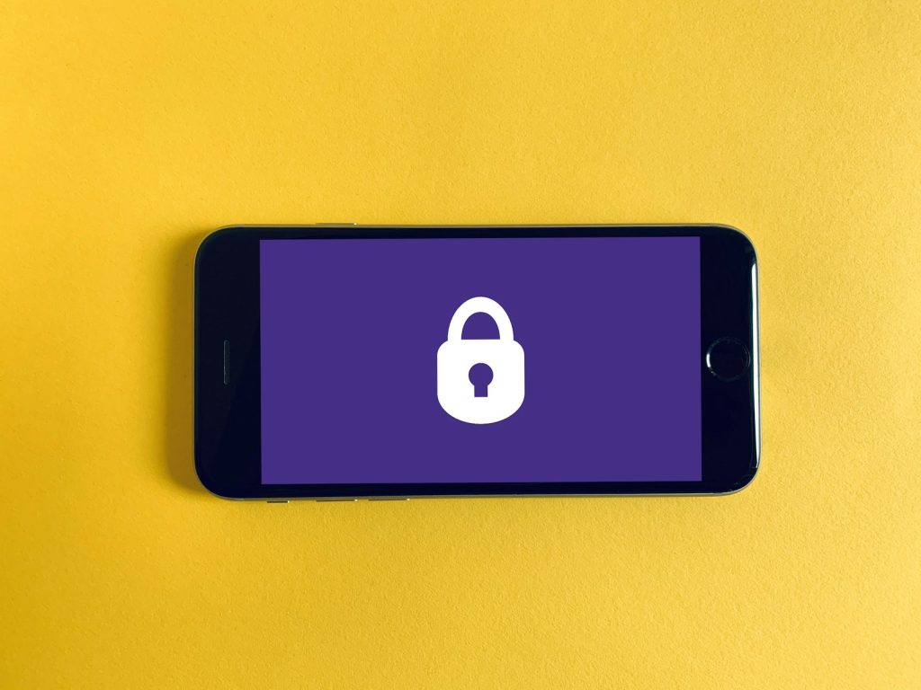 Smartphone showing a padlock security screen on a yellow background