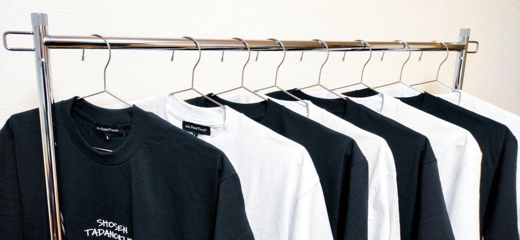 Plain black and white T-shirts hanging on a rail