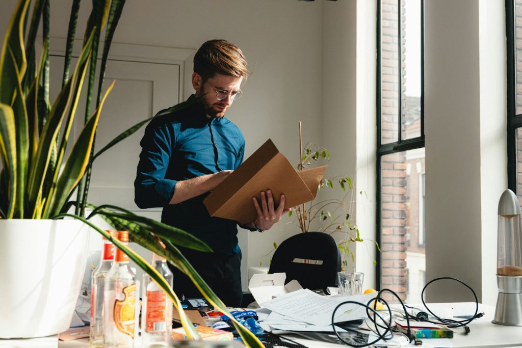 Small business owner holding a parcel in his workspace