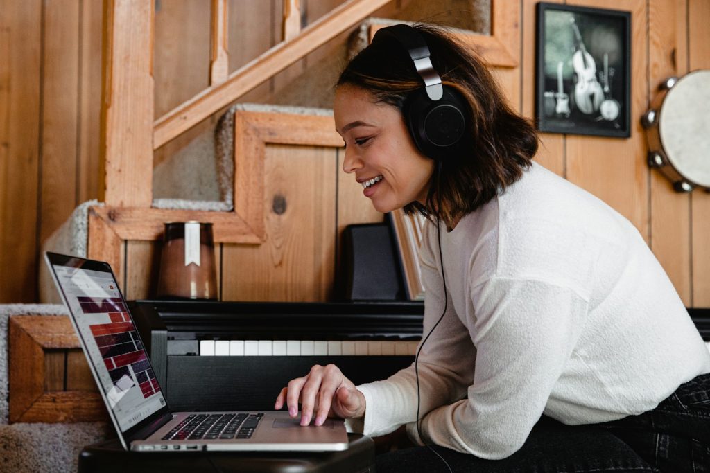 Woman wearing headphones typing on a laptop