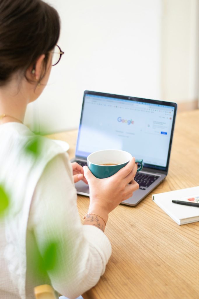 Freelancer holding a mug while working on a laptop