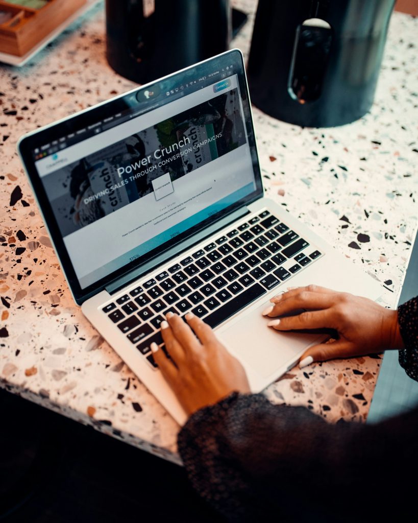 Hands working on a website design on a laptop