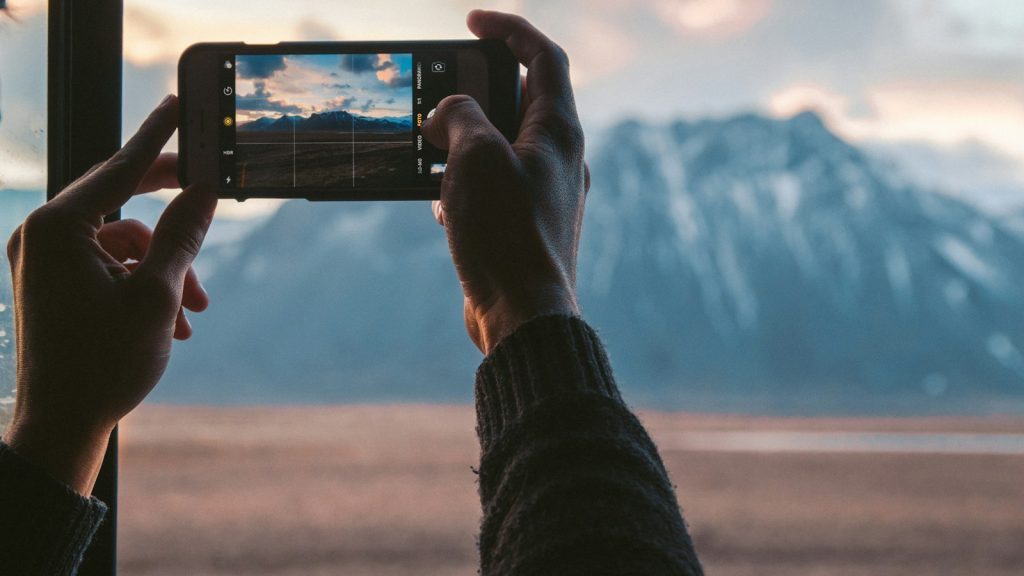 Hands filming vertical video with a smartphone outdoors